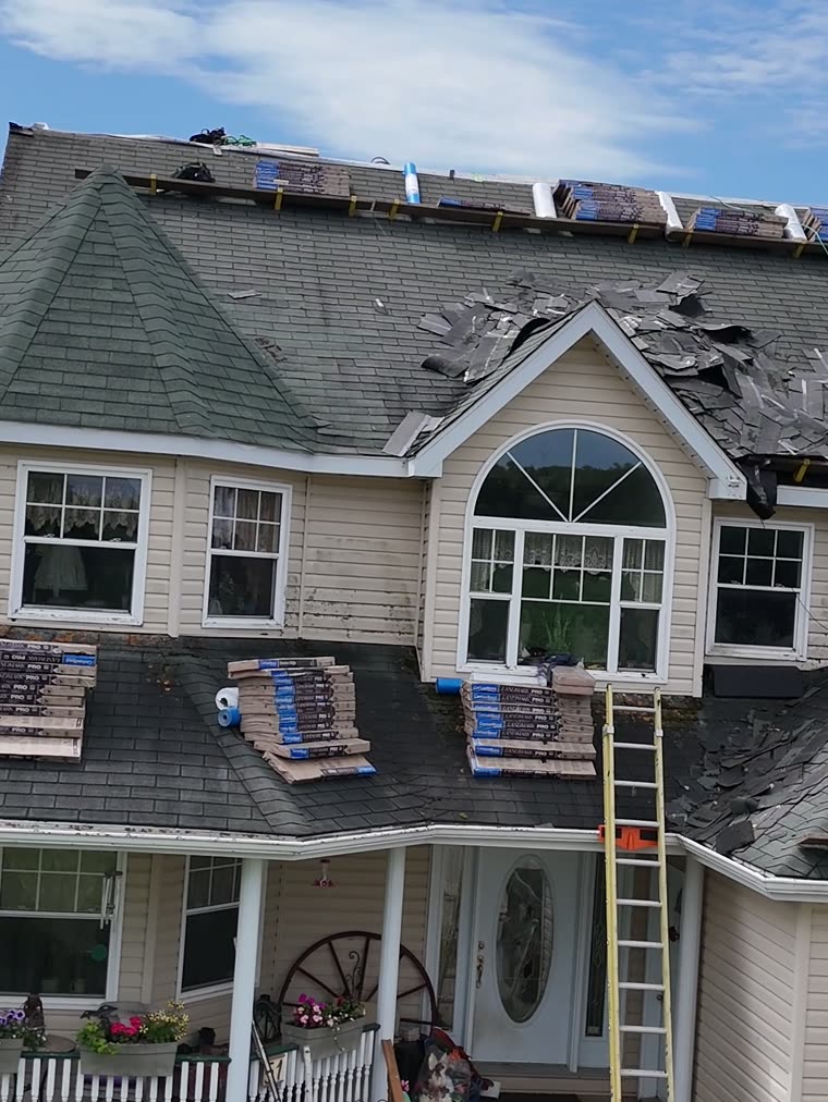 Old shingles stripped off, bundles staged on the roof