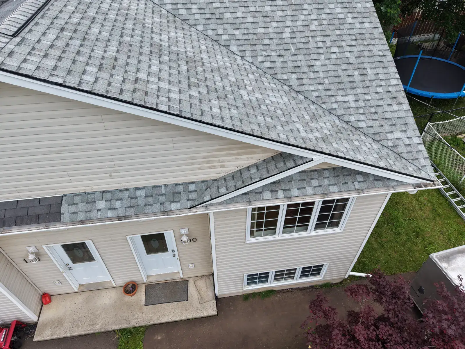 this Moncton duplex after its reroof: new light-grey architectural shingles over the front entry