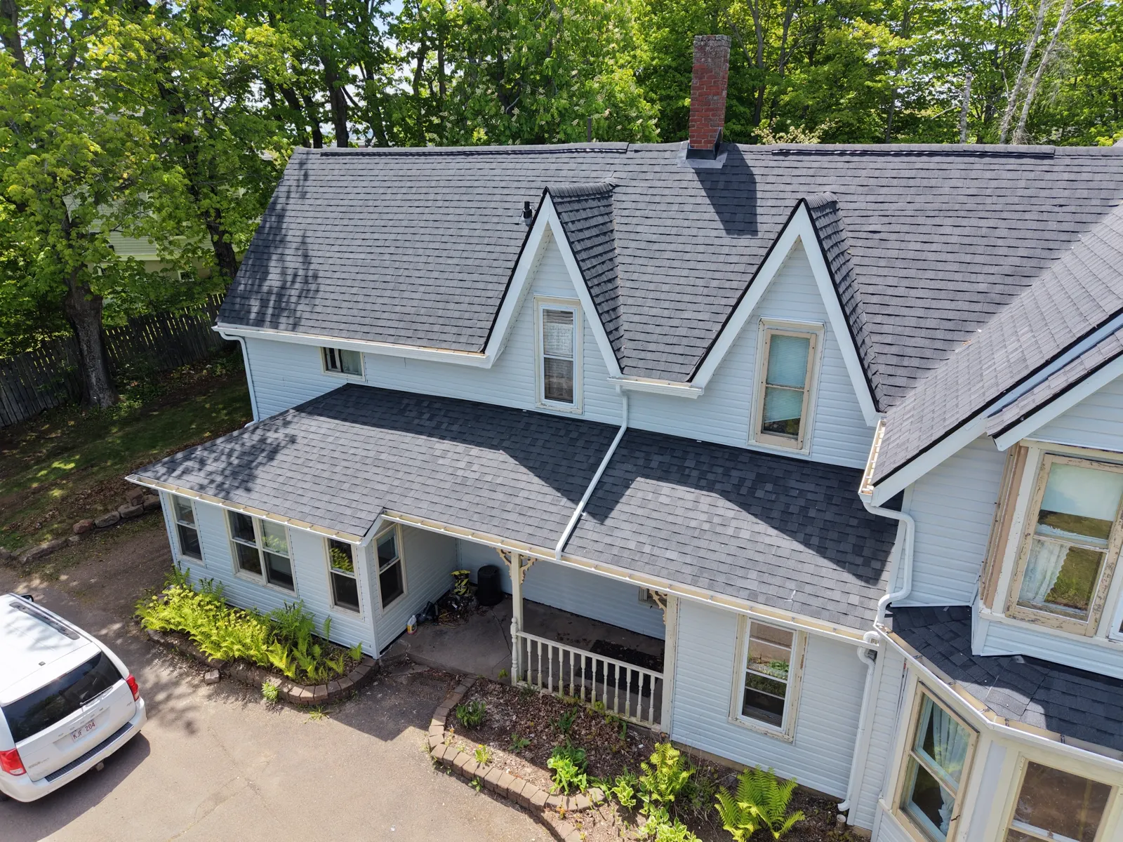 Restored Victorian home in Sackville with new black roof and wide front porch, photographed from the street